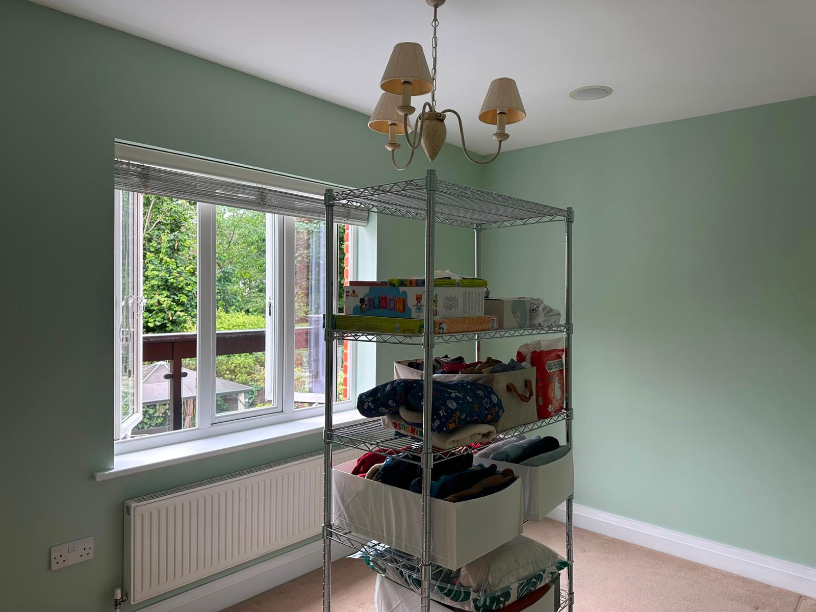 Bedroom painted mint green with white window and skirting