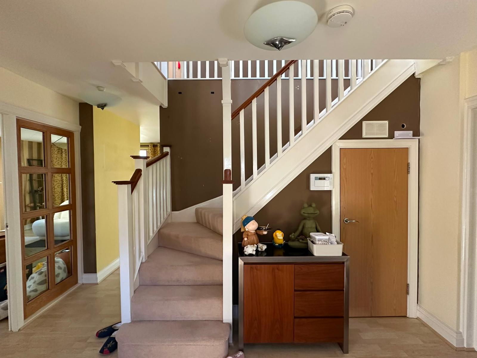 Before photo of a hallway staircase with dark brown walls