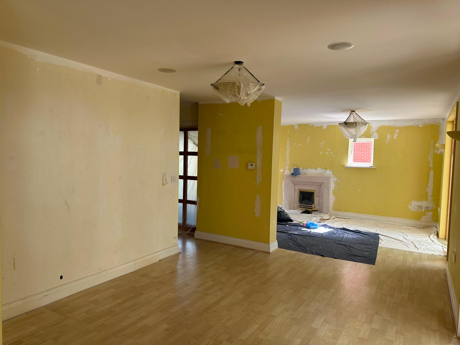 Before photo of a yellow living room with filled patches