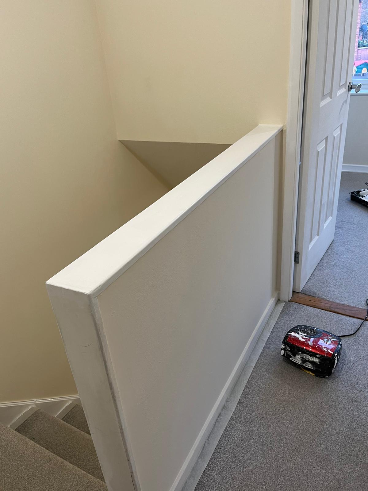 Painted banister wall at the top of the stairs