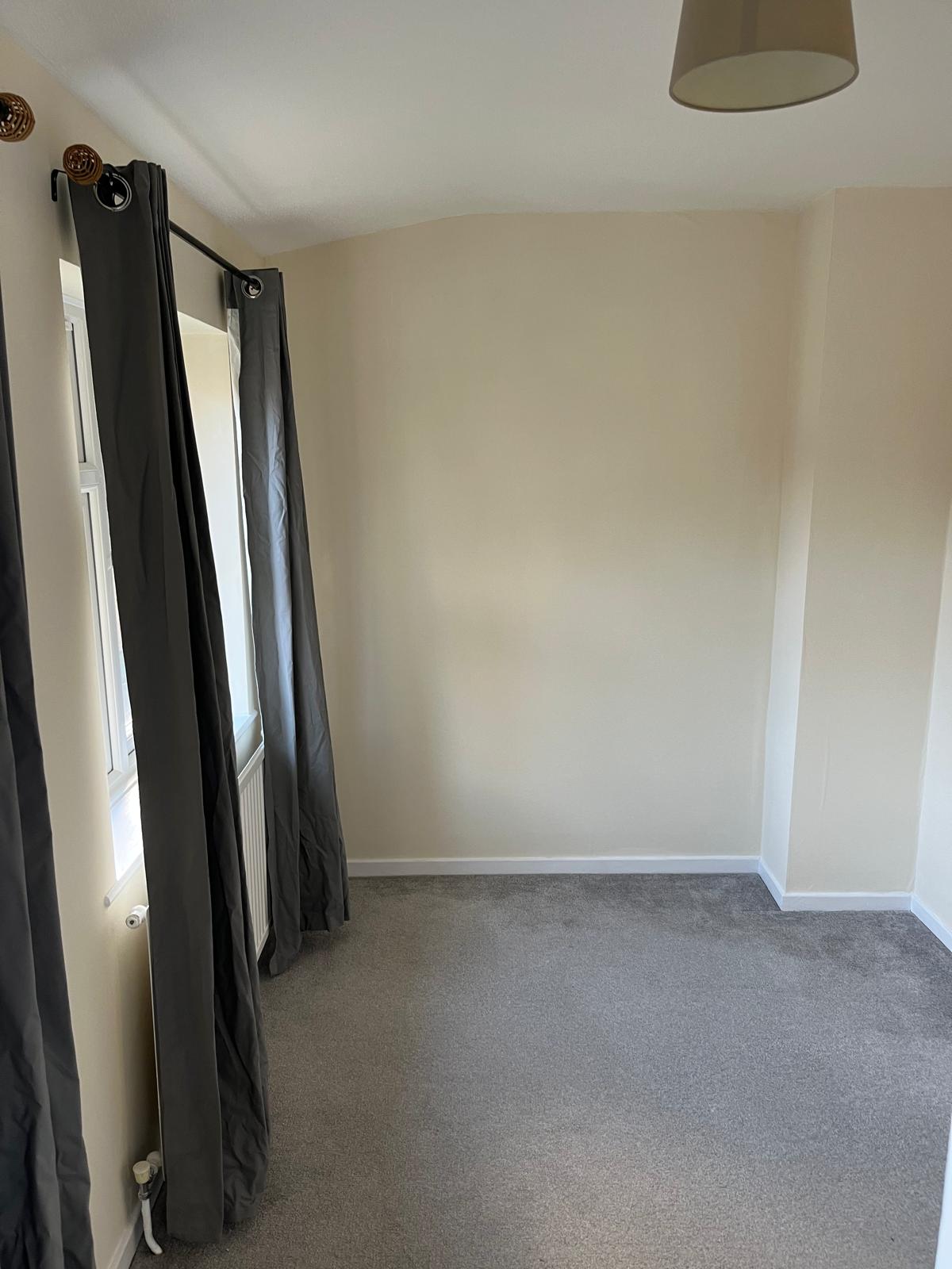 Bedroom corner with cream walls and white skirting