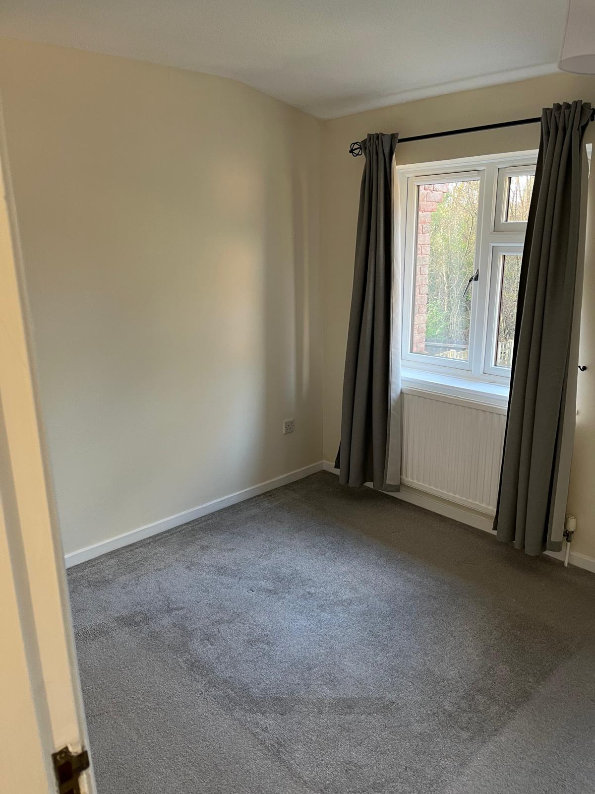 Bedroom with cream walls, white skirting and window