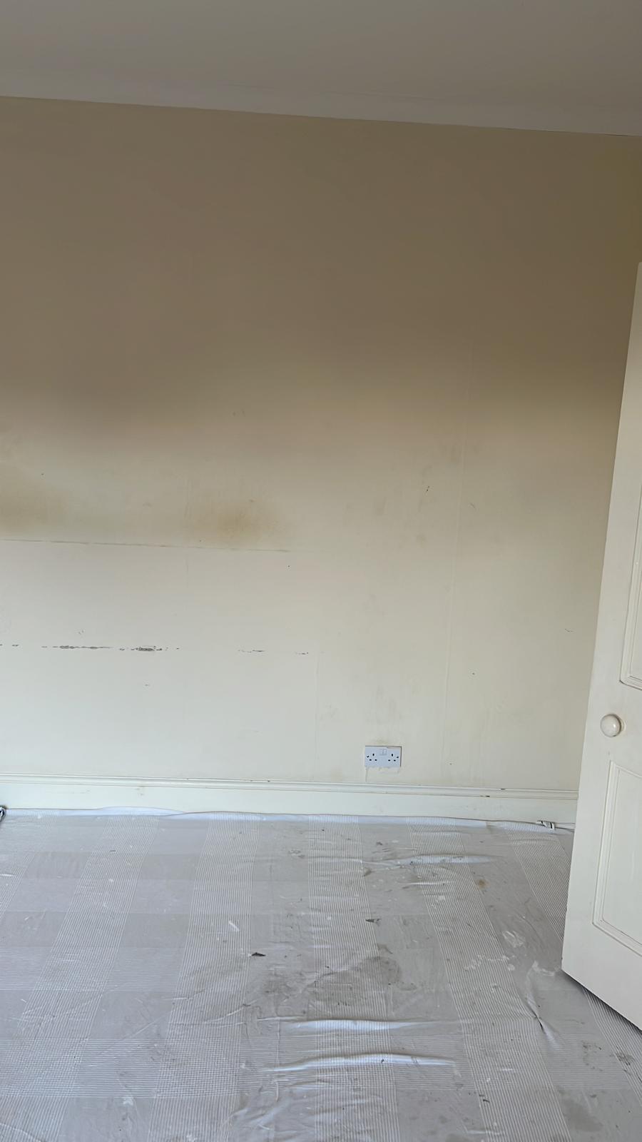 Before photo of a stained bedroom wall