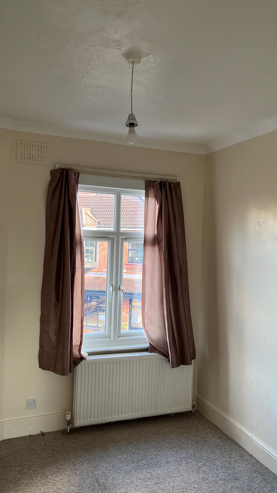 Small bedroom with cream walls, white ceiling and window
