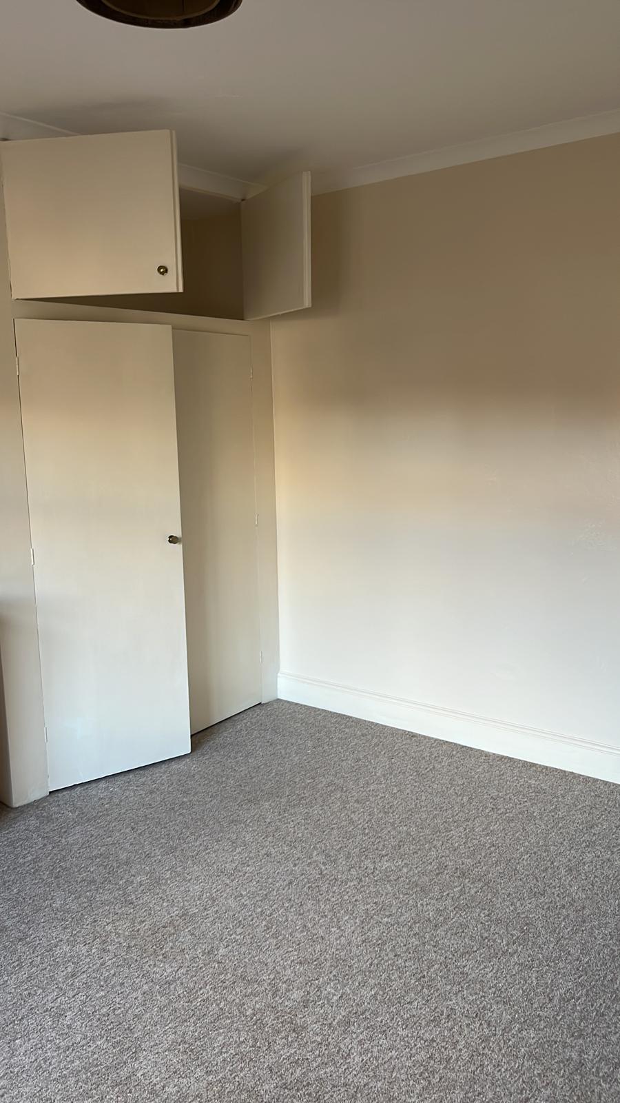 Bedroom with freshly painted walls and built-in cupboards